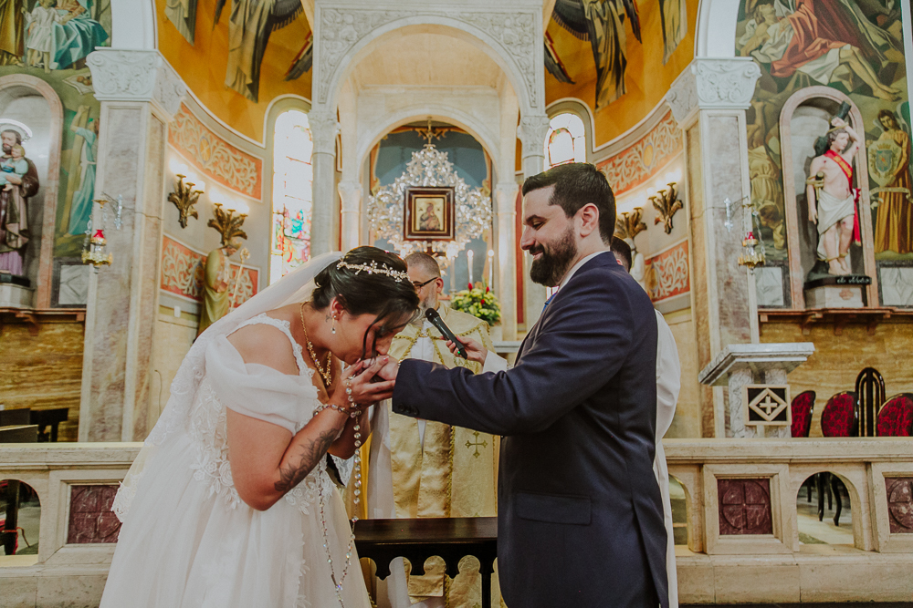Noivos diante do altar trocando alianças durante a celebração do Sacramento do Matrimônio em casamento católico no Grajaú, Rio de Janeiro. Fotografia de casamento por Aline Lelles do Atelier Fotografia Afetiva