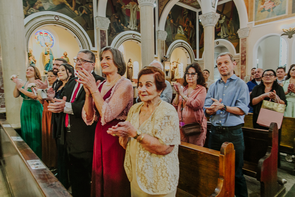 Noivos diante do altar trocando alianças durante a celebração do Sacramento do Matrimônio em casamento católico no Grajaú, Rio de Janeiro. Fotografia de casamento por Aline Lelles do Atelier Fotografia Afetiva