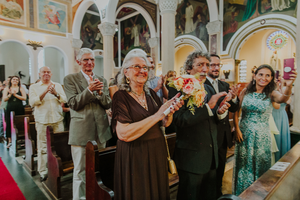 Noivos diante do altar trocando alianças durante a celebração do Sacramento do Matrimônio em casamento católico no Grajaú, Rio de Janeiro. Fotografia de casamento por Aline Lelles do Atelier Fotografia Afetiva
