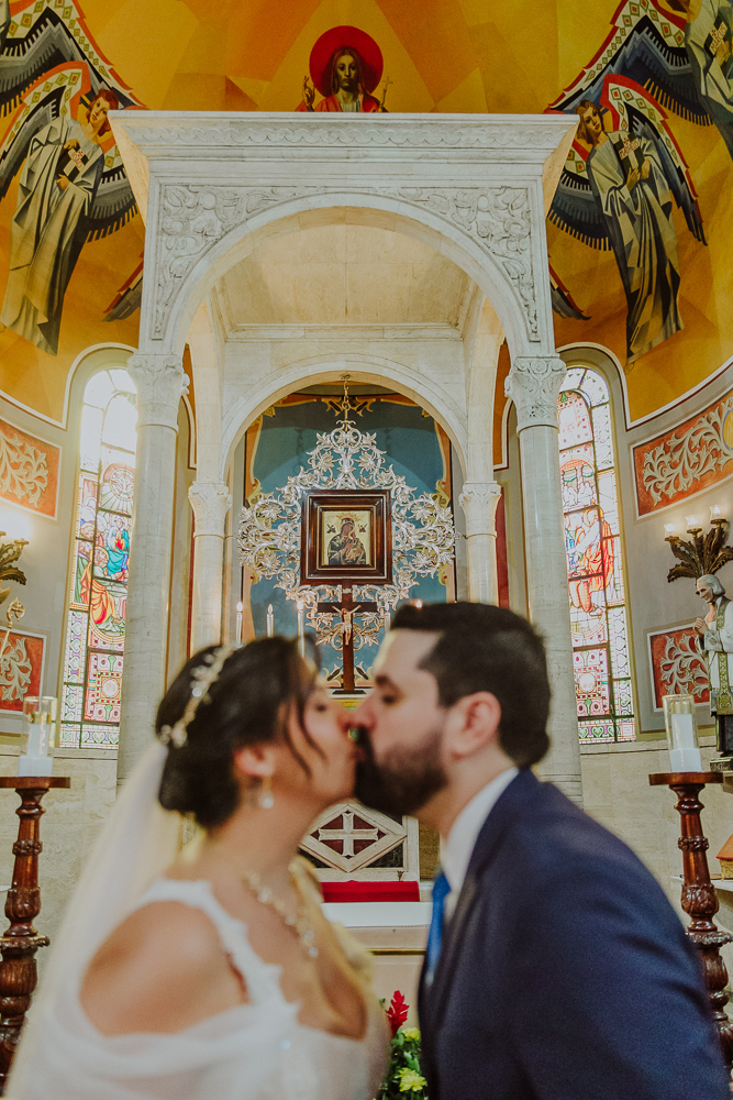 Noivos venerando a imagem de Nossa Senhora do Perpétuo Socorro durante a celebração do Sacramento do Matrimônio em casamento católico no Grajaú, Rio de Janeiro. Fotografia de casamento por Aline Lelles do Atelier Fotografia Afetiva