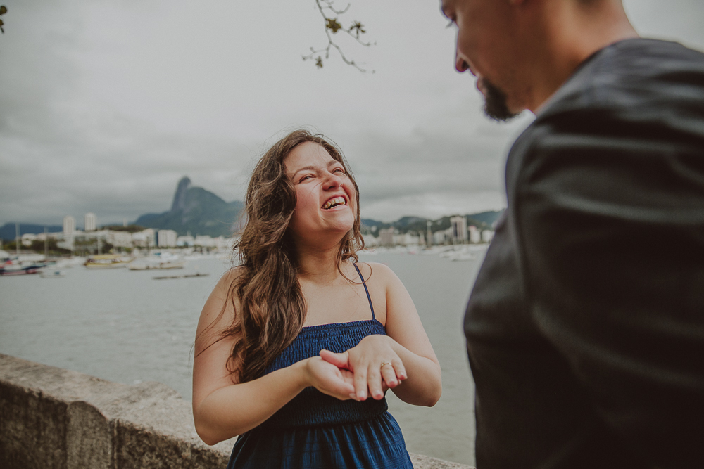 Registro em preto e branco da reação de Alana ao receber a aliança durante o pedido de casamento na Mureta da Urca, no Rio de Janeiro.