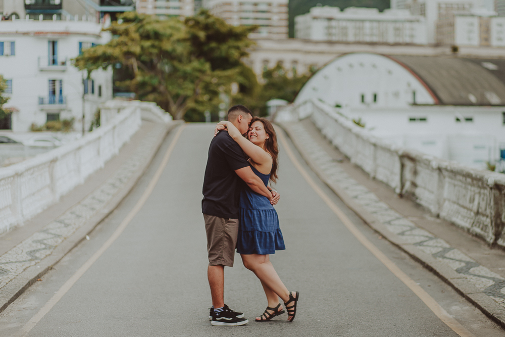 casal abraçadospela Urca durante o ensaio realizado após o pedido de casamento, em uma fotografia espontânea do casal.