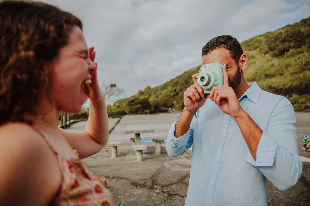 Mulher se emociona ao ser fotografada pelo companheiro com uma câmera instantânea, na Praia do Secreto RJ.