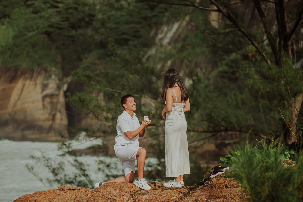 Diego se arrodilla frente a María para pedirle matrimonio sobre las rocas del Mirante da Joatinga, en Río de Janeiro, Brasil.