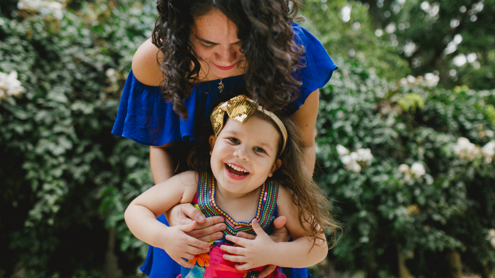mae e filha se divertem no ensaio de familia no jardim botanico