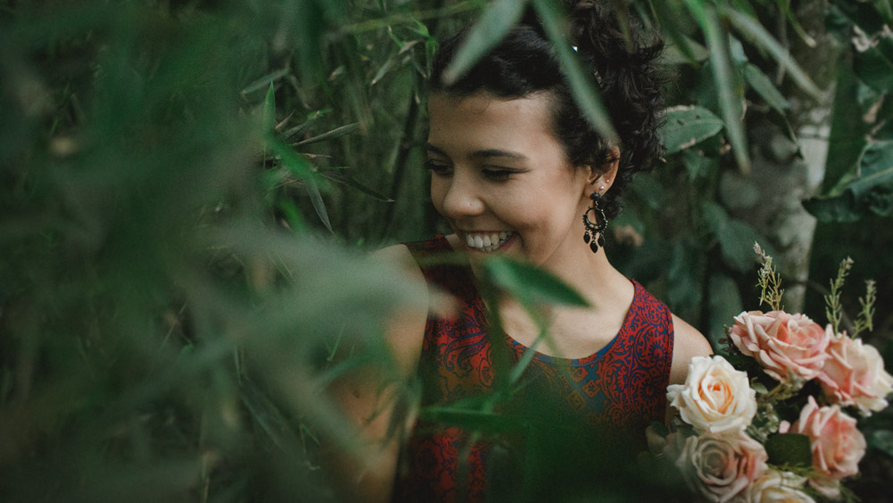 Meio t&iacute;mida e com ar de menina, Nathalia Lovati se esconde por traz das folhas.