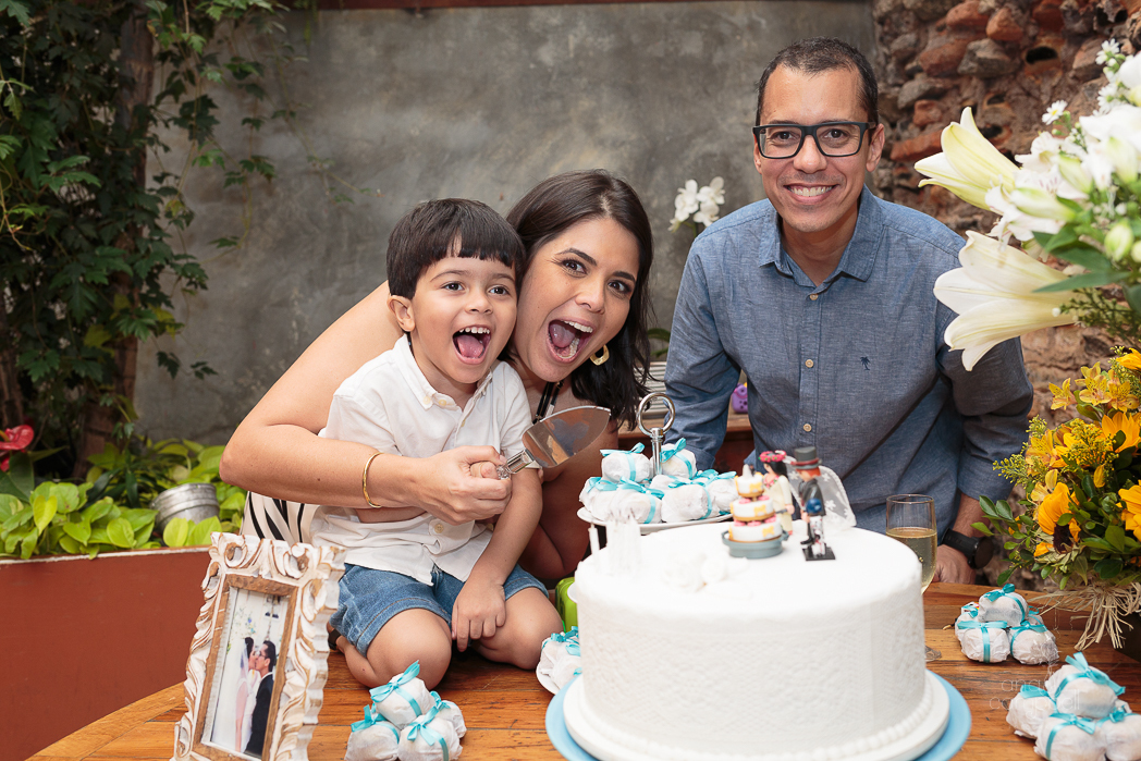 foto dos noivos e o filho próximo ao bolo
