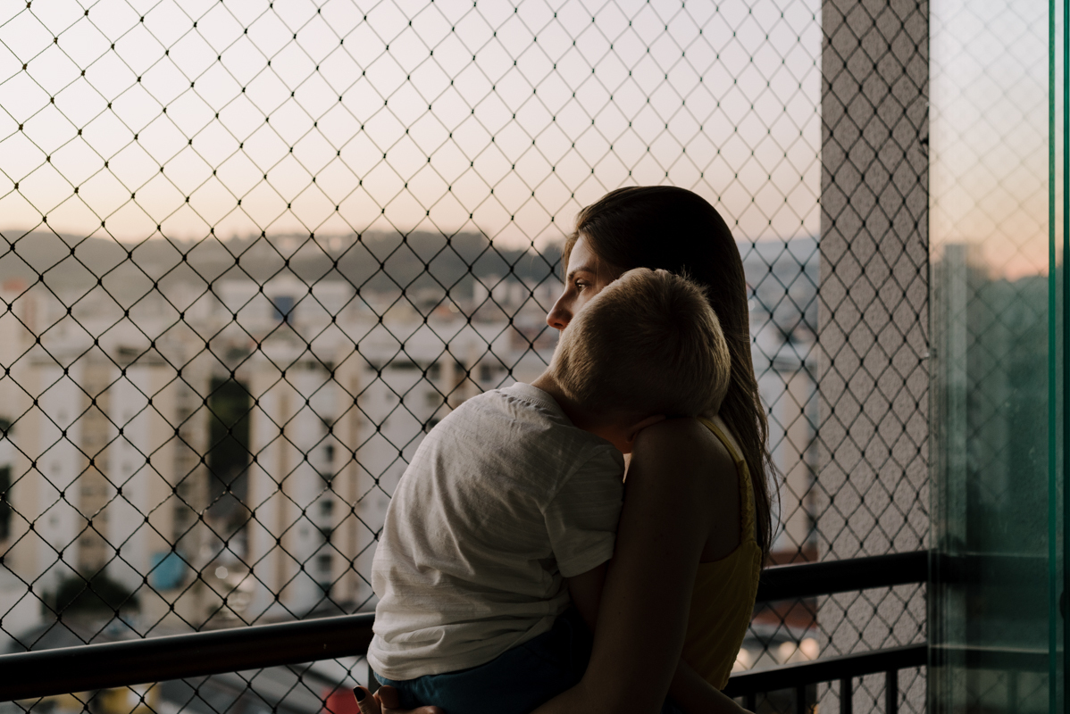 Família observando a paisagem ao pôr do sol na varanda, refletindo a calma e a conexão entre todos em um momento tranquilo
