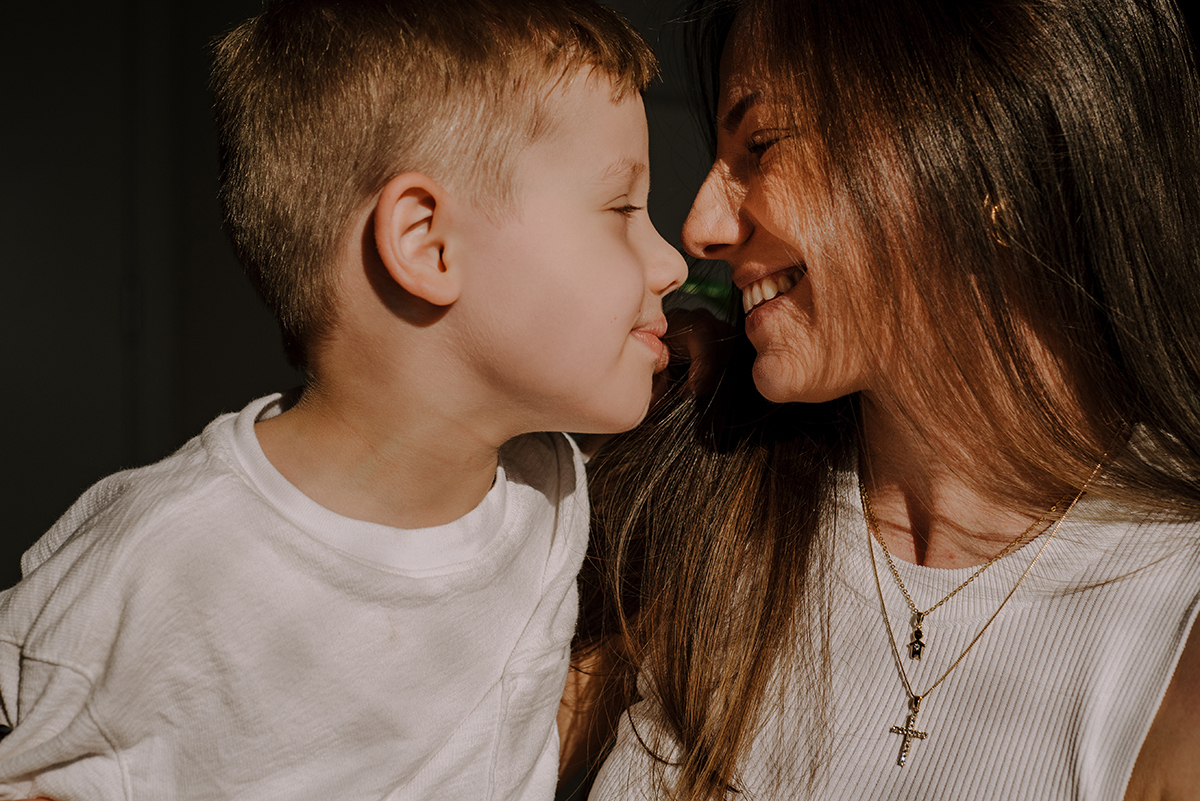 Mãe e filho se abraçando, mostrando uma conexão cheia de amor e carinho em um momento tranquilo e íntimo dentro de casa.