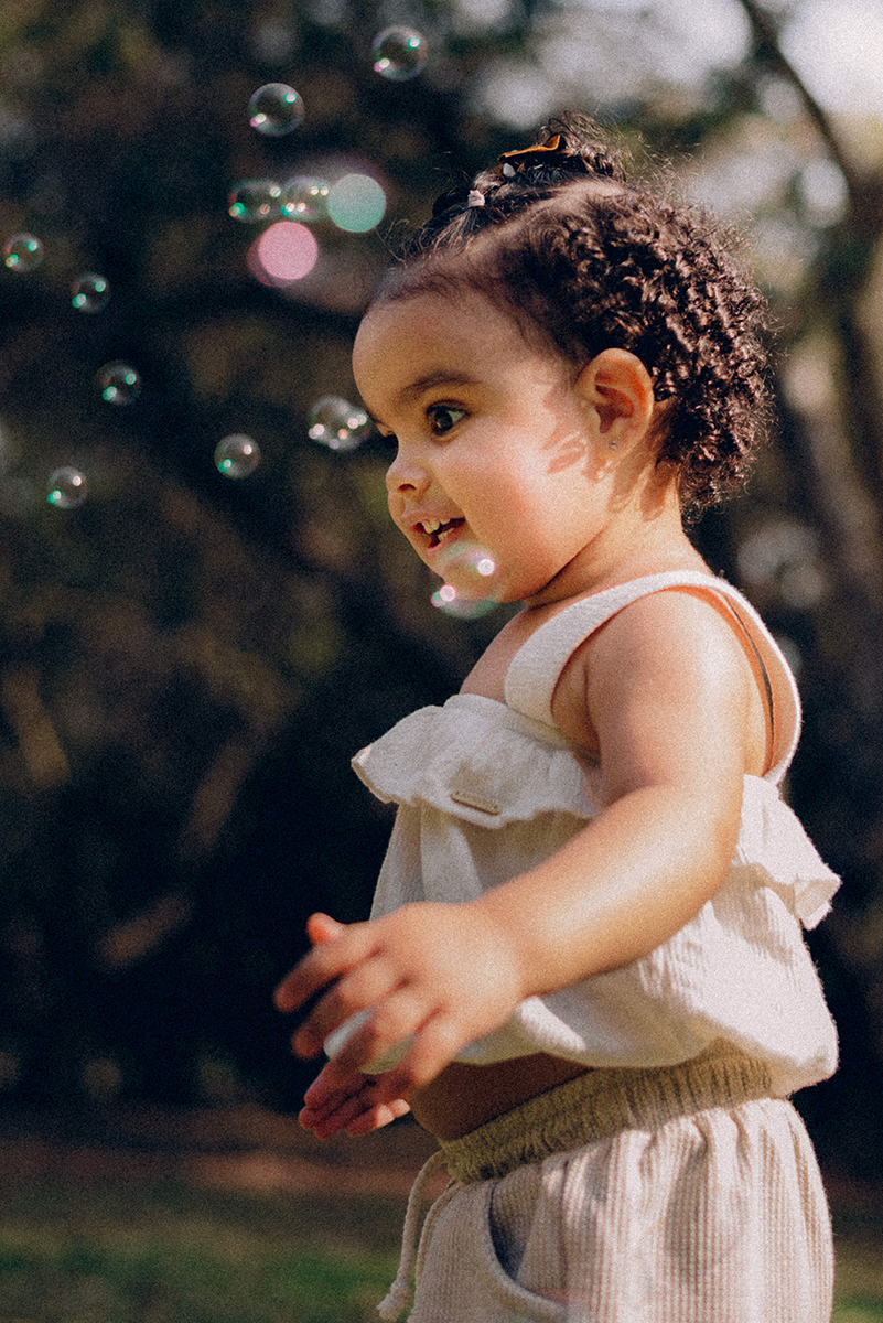 Ensaio de família lifestyle no Parque Villa-Lobos, São Paulo; fotografia documental, luz natural suave em tarde nublada, bolhas de sabão, piquenique, fotos espontâneas, fotógrafo de família SP, memórias afetivas, Isabelly, fim de tarde.