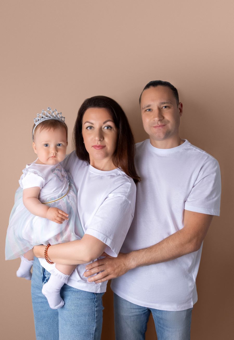 Mum hugging baby father hugging both family portrait