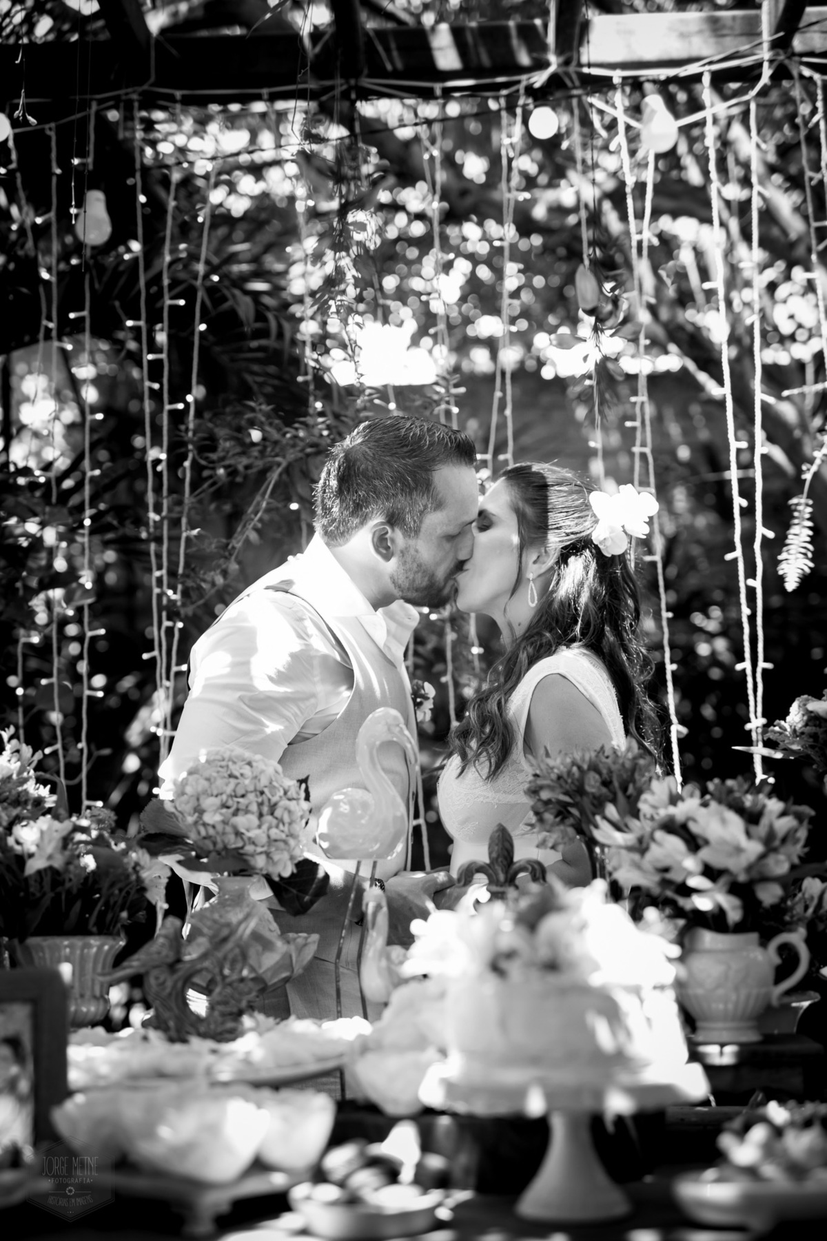 noivois se beijando na mesa de doces