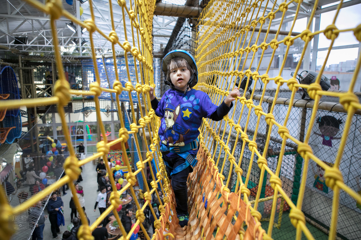 lindo menino fazendo arborismo no buffet infantil espaço lá vem o sol em São Paulo