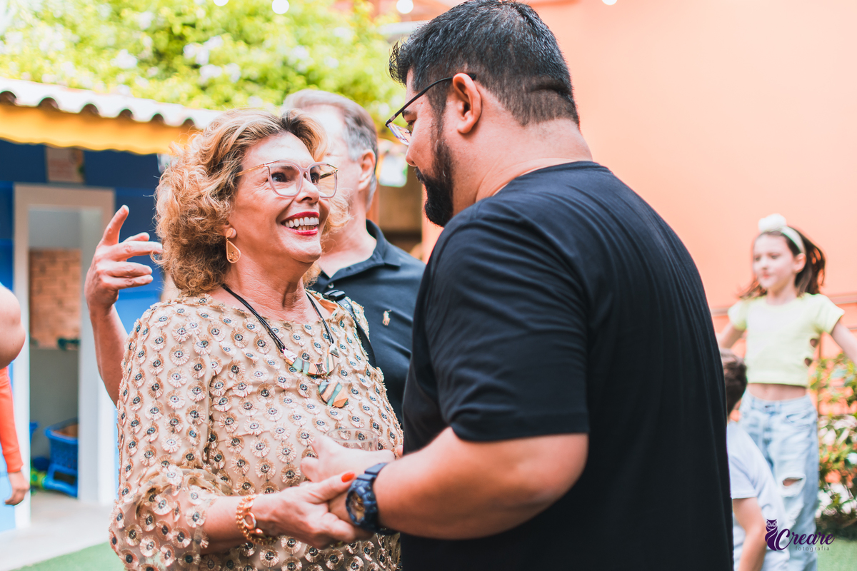 aniversário infantil, festa de menina com tema casa mágica de Gabby. festa realizada no buffet Quintal das Aroeiras em Santo André, ABC Paulista. A imagem contém: um homém jovem de camisa preta e barba, conversando com mulher mais velha e blusa clara.