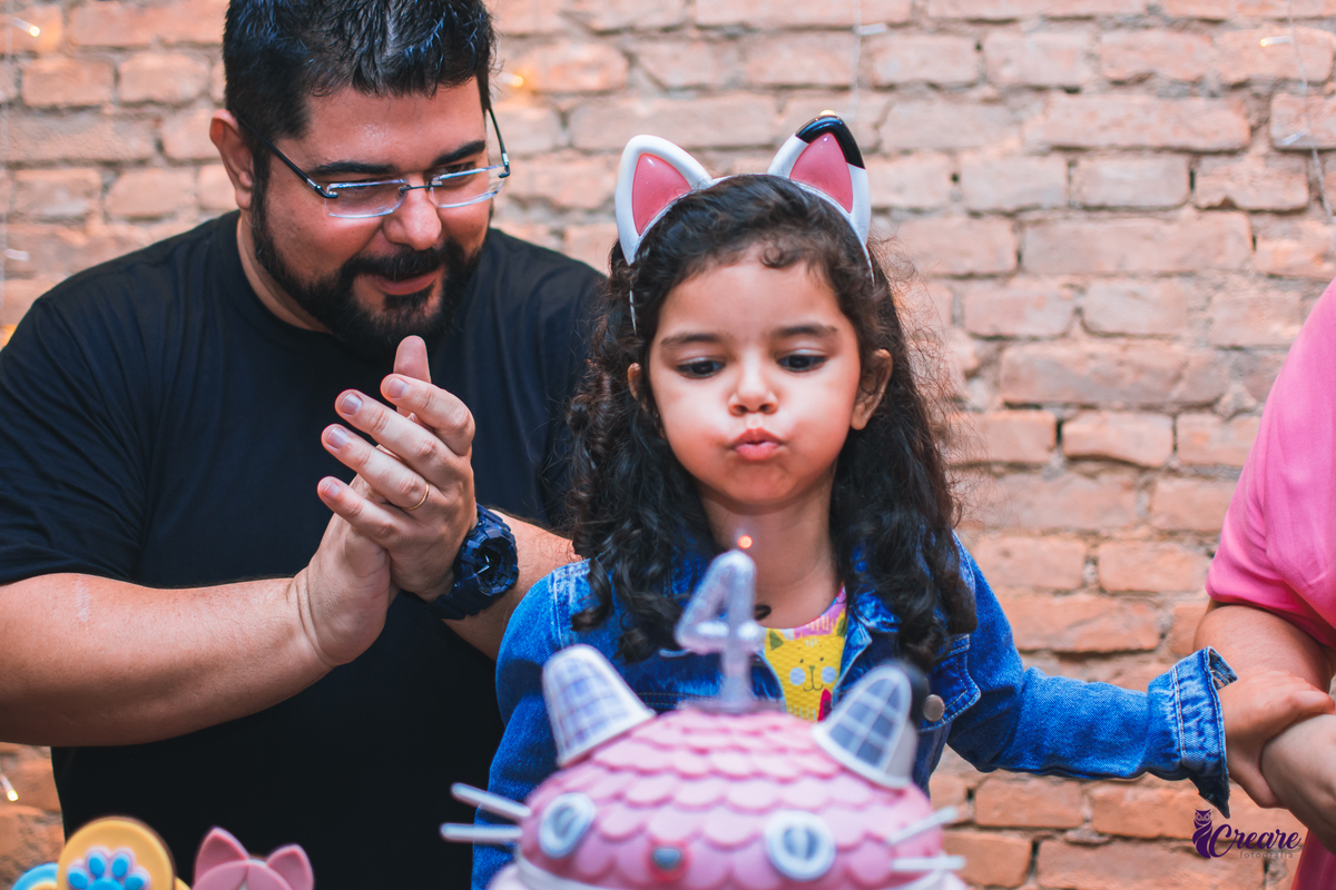 aniversário infantil, festa de menina com tema casa mágica de Gabby. festa realizada no buffet Quintal das Aroeiras em Santo André, ABC Paulista. imagem contém: 2 adultos e uma criança na mesa do parabéns.