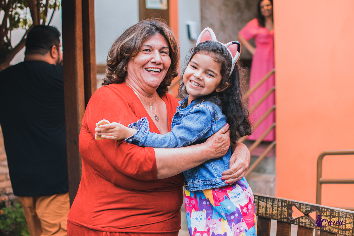 aniversário infantil, festa de menina com tema casa mágica de Gabby. festa realizada no buffet Quintal das Aroeiras em Santo André, ABC Paulista. a imagem contém: uma crianca de cabelo cacheado e jaqueta azul com uma mulher mais velha de blusa vermelha.
