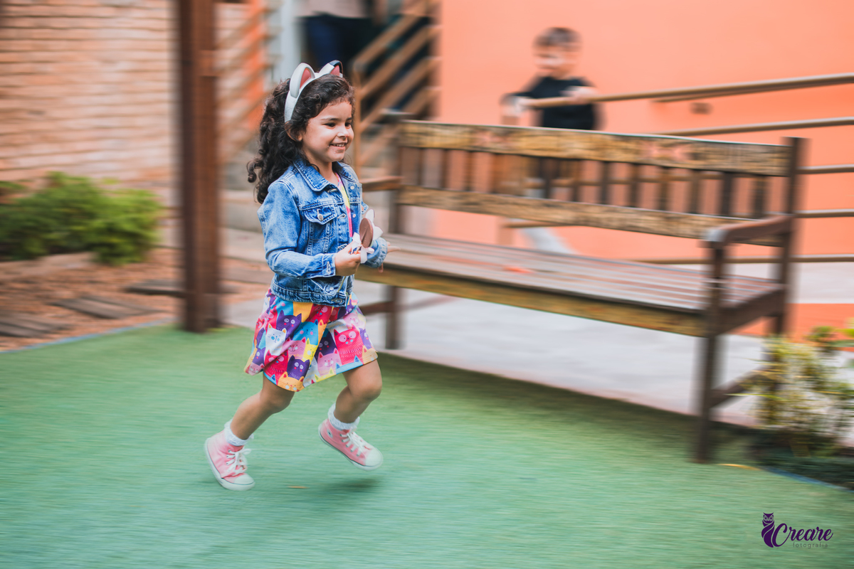 aniversário infantil, festa de menina com tema casa mágica de Gabby. festa realizada no buffet Quintal das Aroeiras em Santo André, ABC Paulista. imagem contém: uma criança de cabelos pretos e cacheados, com jaqueta azul, correndo