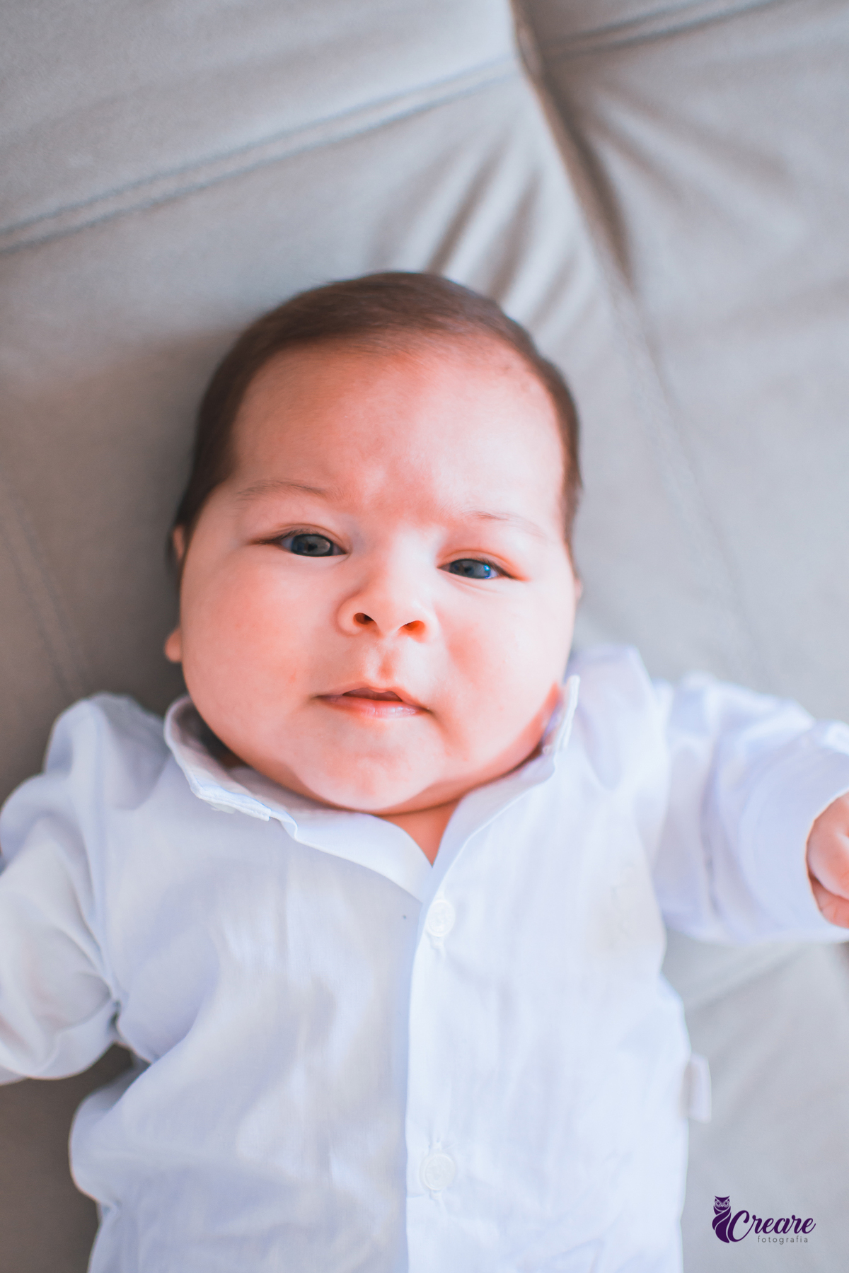 Ensaio newborn lifestyle, ensaio família. A imagem contém: um homem jovem com roupa branca, uma mulher jovem com roupa branca, um bebê com roupa branca e bermuda bege com suspensório. fotógrafo Mauá, ensaio lifestyle. 