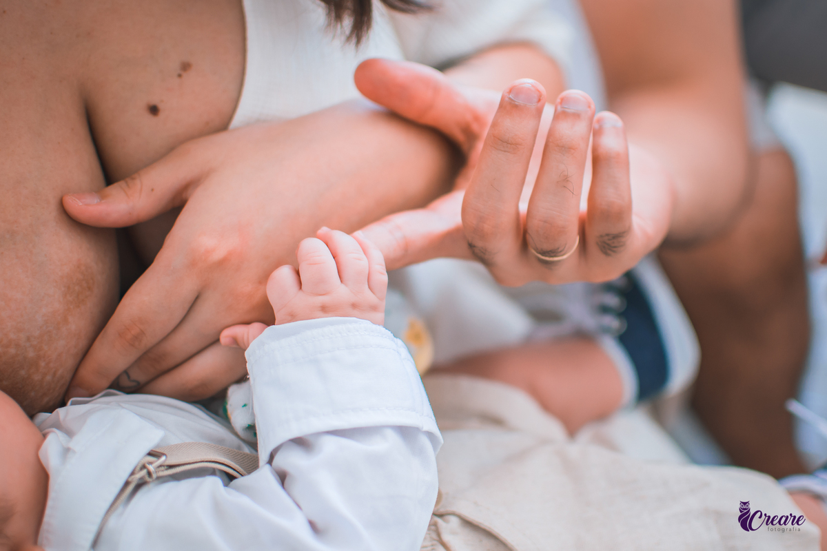 Ensaio newborn lifestyle, ensaio família. A imagem contém: um homem jovem com roupa branca, uma mulher jovem com roupa branca, um bebê com roupa branca e bermuda bege com suspensório. fotógrafo Mauá, ensaio lifestyle. 