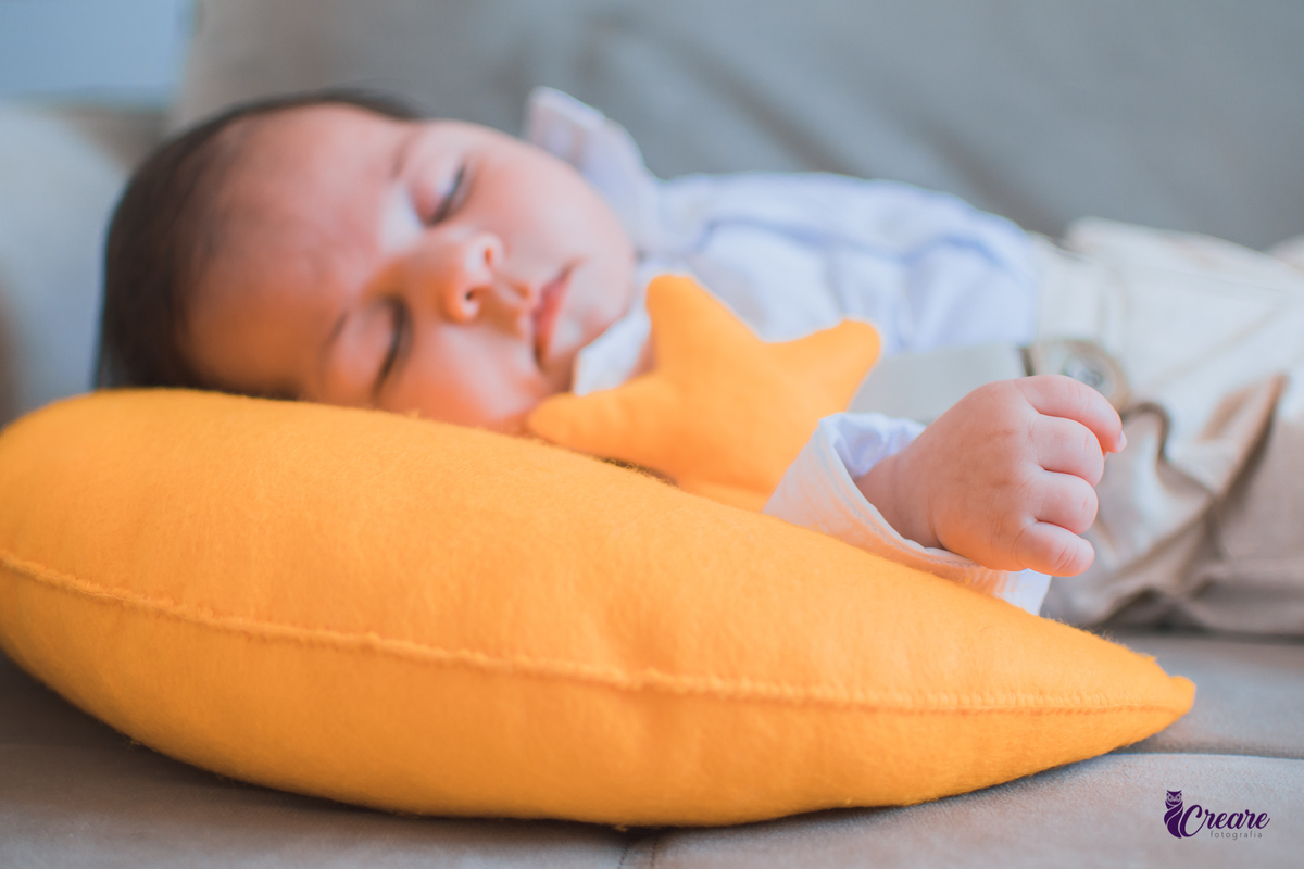 Ensaio newborn lifestyle, ensaio família. A imagem contém: um homem jovem com roupa branca, uma mulher jovem com roupa branca, um bebê com roupa branca e bermuda bege com suspensório. fotógrafo Mauá, ensaio lifestyle. 
