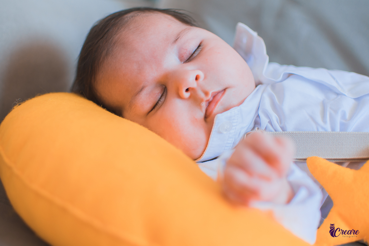 Ensaio newborn lifestyle, ensaio família. A imagem contém: um homem jovem com roupa branca, uma mulher jovem com roupa branca, um bebê com roupa branca e bermuda bege com suspensório. fotógrafo Mauá, ensaio lifestyle. 