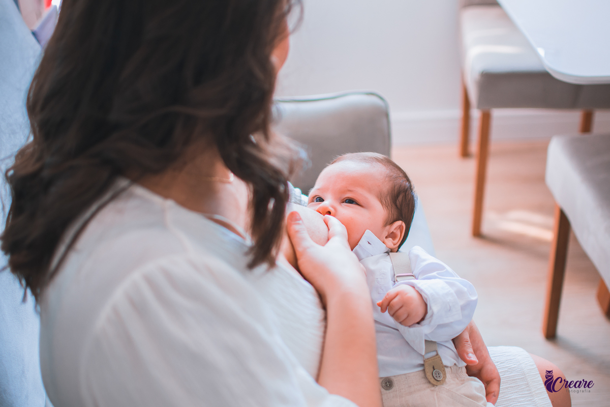 Ensaio newborn lifestyle, ensaio família. A imagem contém: um homem jovem com roupa branca, uma mulher jovem com roupa branca, um bebê com roupa branca e bermuda bege com suspensório. fotógrafo Mauá, ensaio lifestyle. 