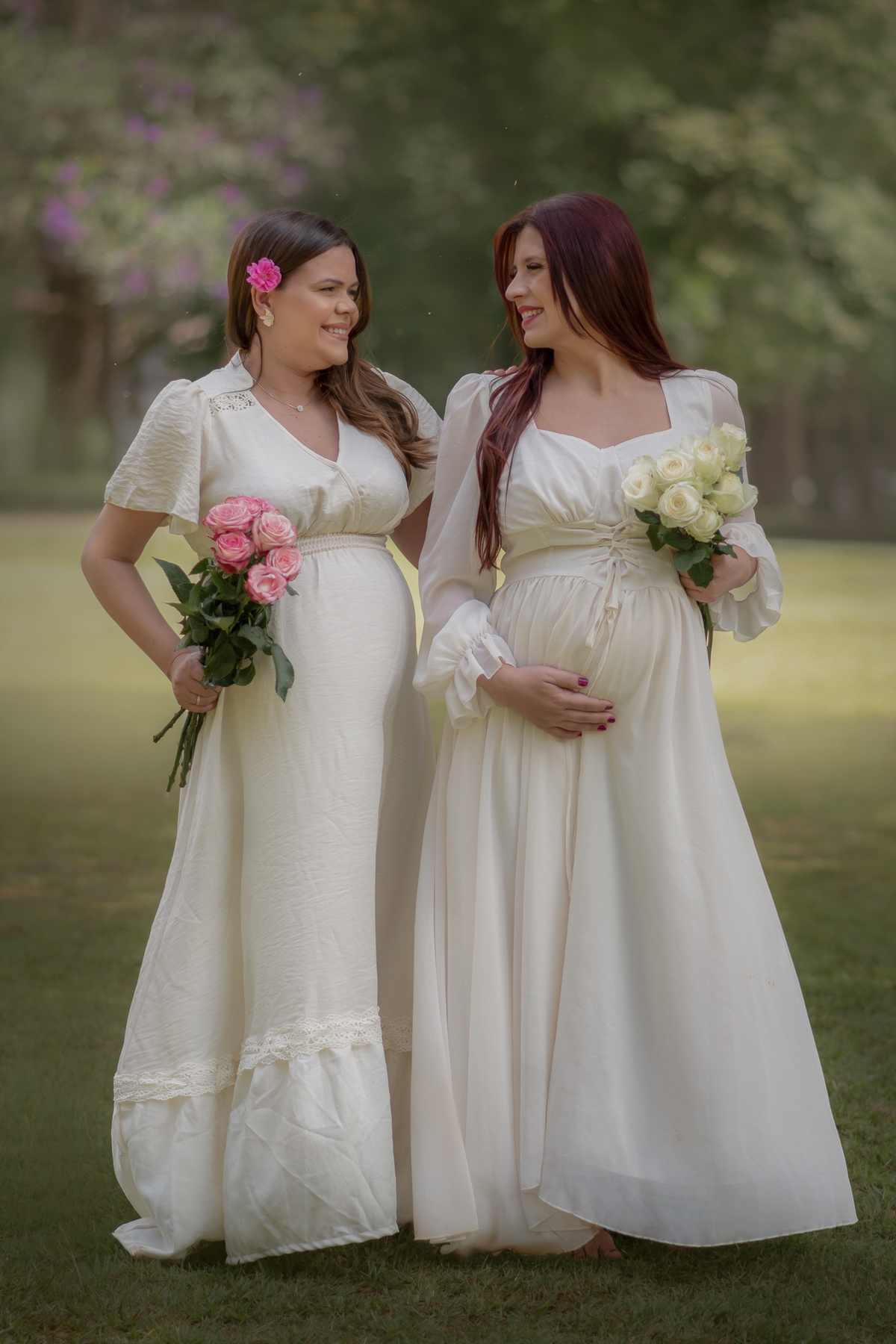 Duas mulheres de vestido branco ambas gestante em um ensaio fotográfico no Parque Chácara SIlvestre em São Bernardo do Campo.