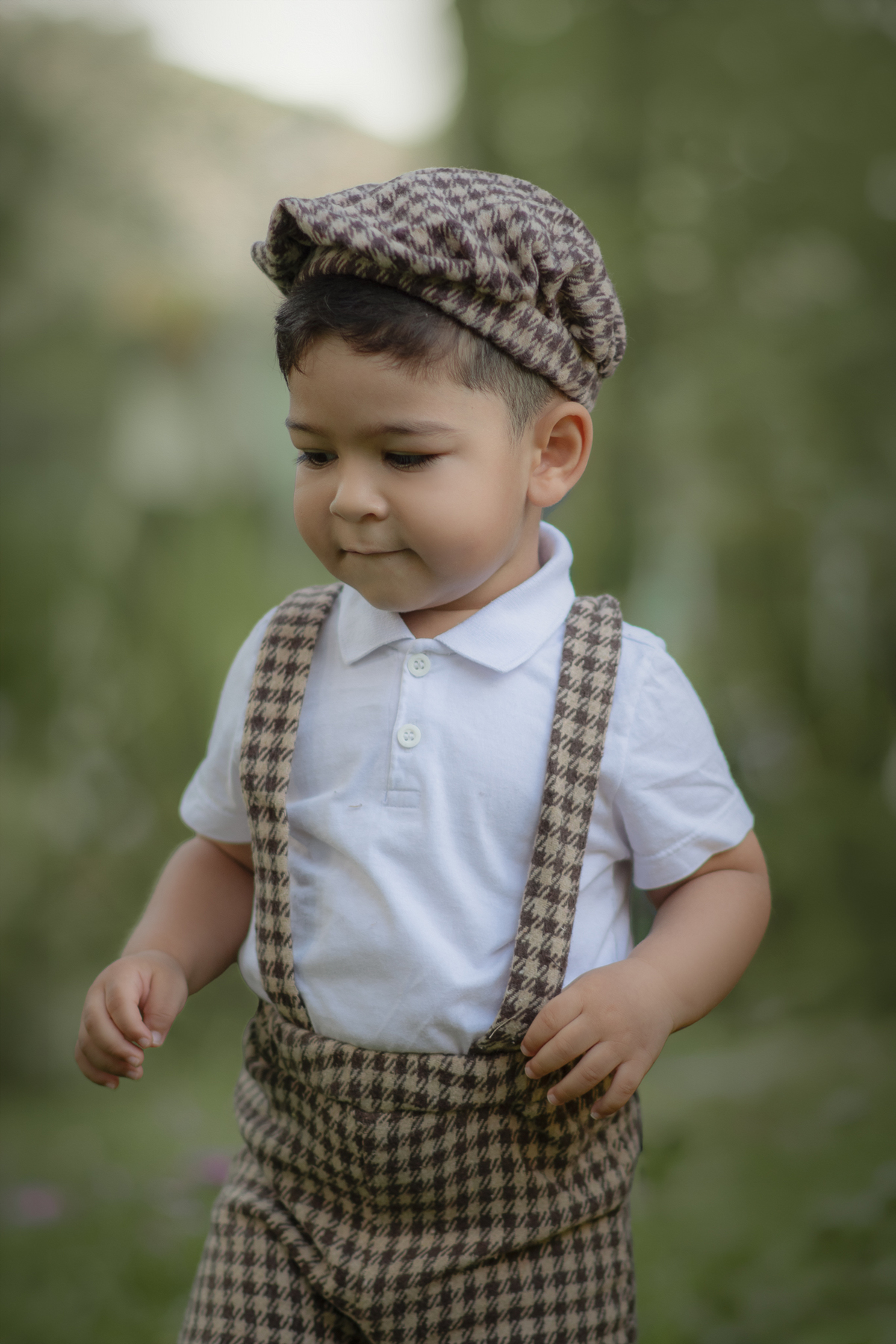 Um menino vestido com roupa camponês brincando em um parque, durante o ensaio fotográfico de dia das mães.