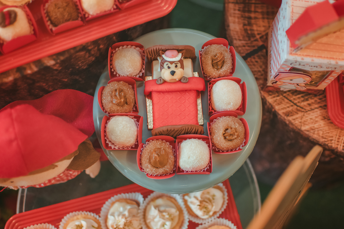 Docês de festa infantil decorado com o lobo mal deitado em uma cama.