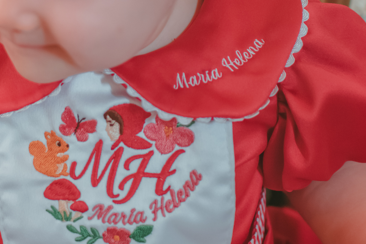 detalhes da roupa de uma bebê de um ano, a gola do vestido escrito Maria Helena