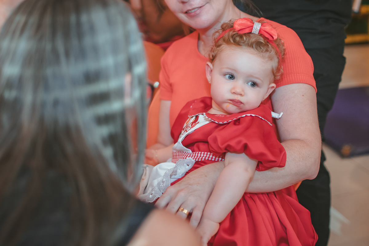 uma bebê observando uma mulher durante seu aniversário de 1 ano.