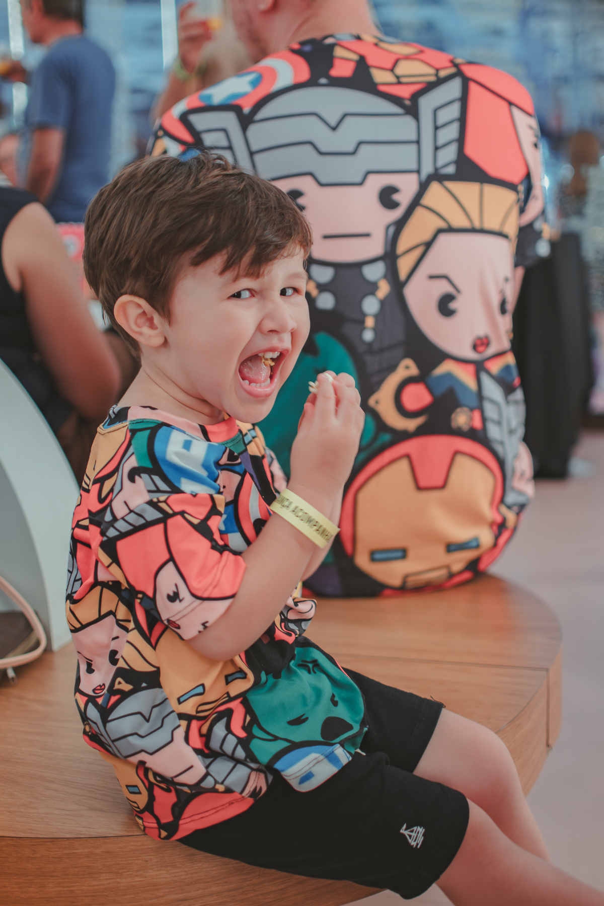 Um menino comendo pipocas durante sua festa de aniversário.