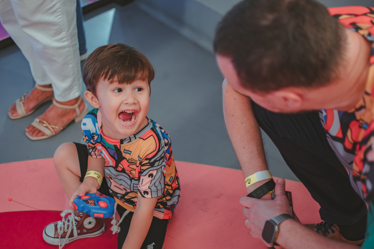 um menino e seu pai, brinancando com um carrinho de controle remoto durante sua festa de aniversário no Playcenter Family.