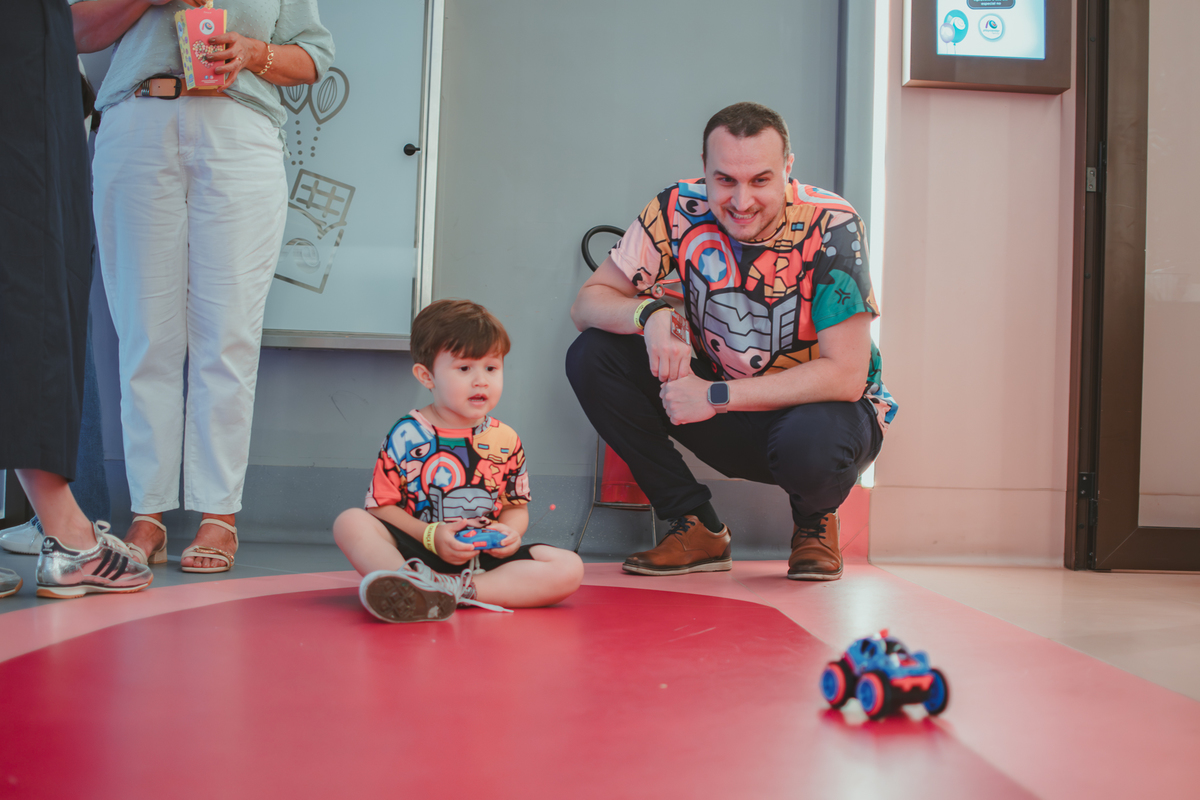 um menino e seu pai, brinancando com um carrinho de controle remoto durante sua festa de aniversário no Playcenter Family.