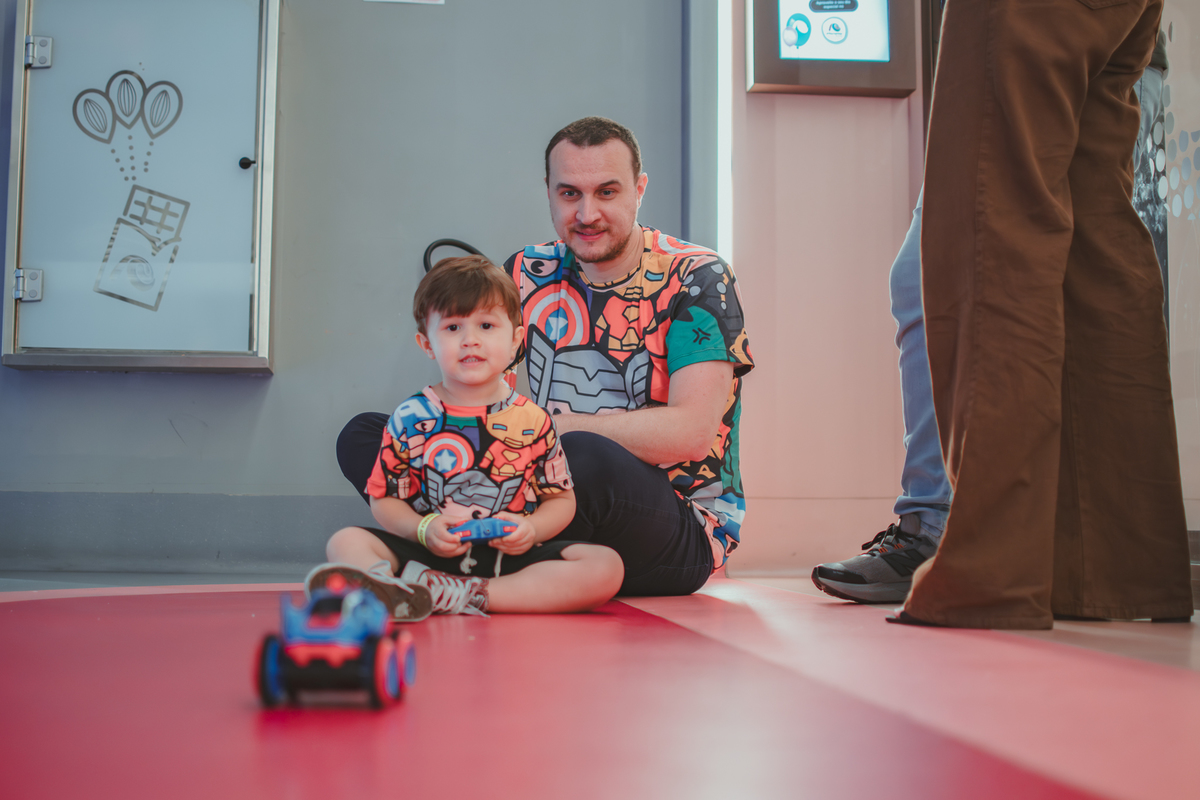 um menino e seu pai, brinancando com um carrinho de controle remoto durante sua festa de aniversário no Playcenter Family.