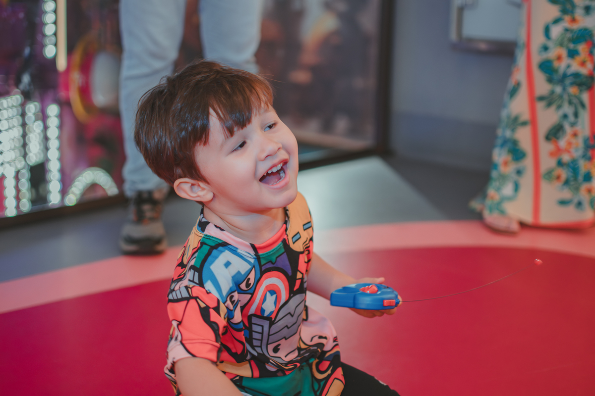 um menino e seu pai, brinancando com um carrinho de controle remoto durante sua festa de aniversário no Playcenter Family.