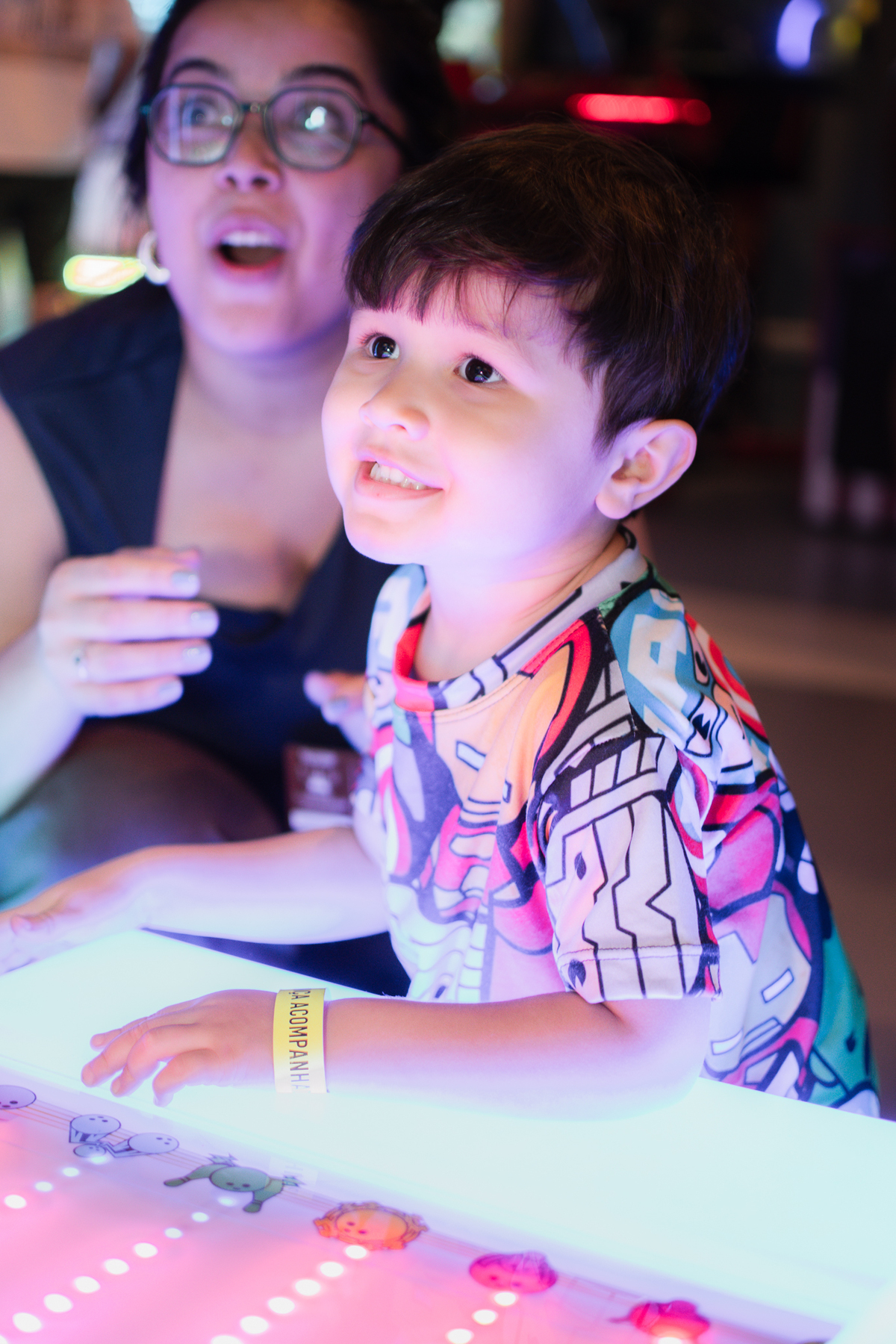Um menino com sua mãe, brincando de boliche no Playcenter family durante sua festa de aniversário.