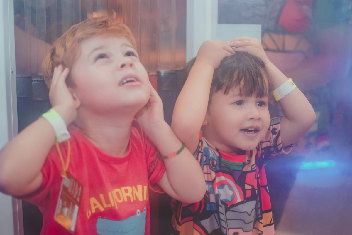 Dois meninos brincando em uma cabine que cai bolinhas de plastico, durante um aniversário no playcenter family.