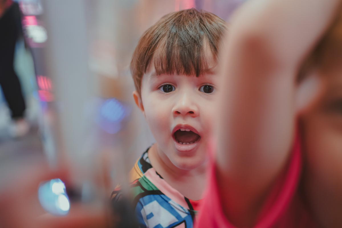 Uma criança olhando surpresa durante uma brincadeira de bolinhas na sua festa de aniversário.
