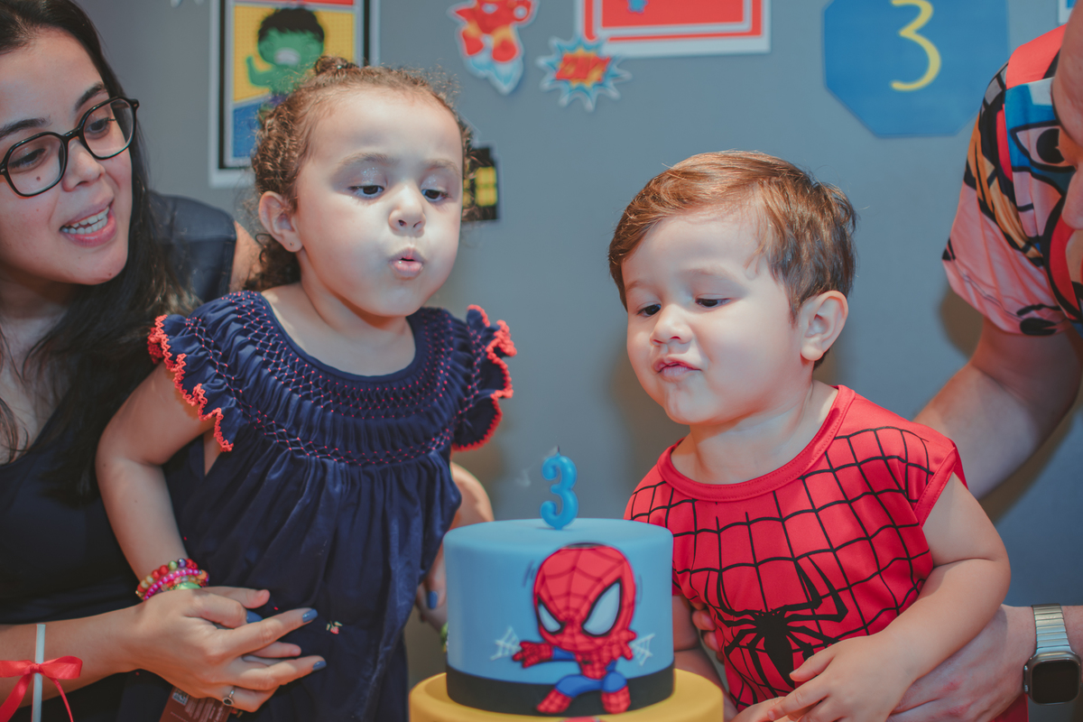 Duas crianças assoprando uma vela de aniversário