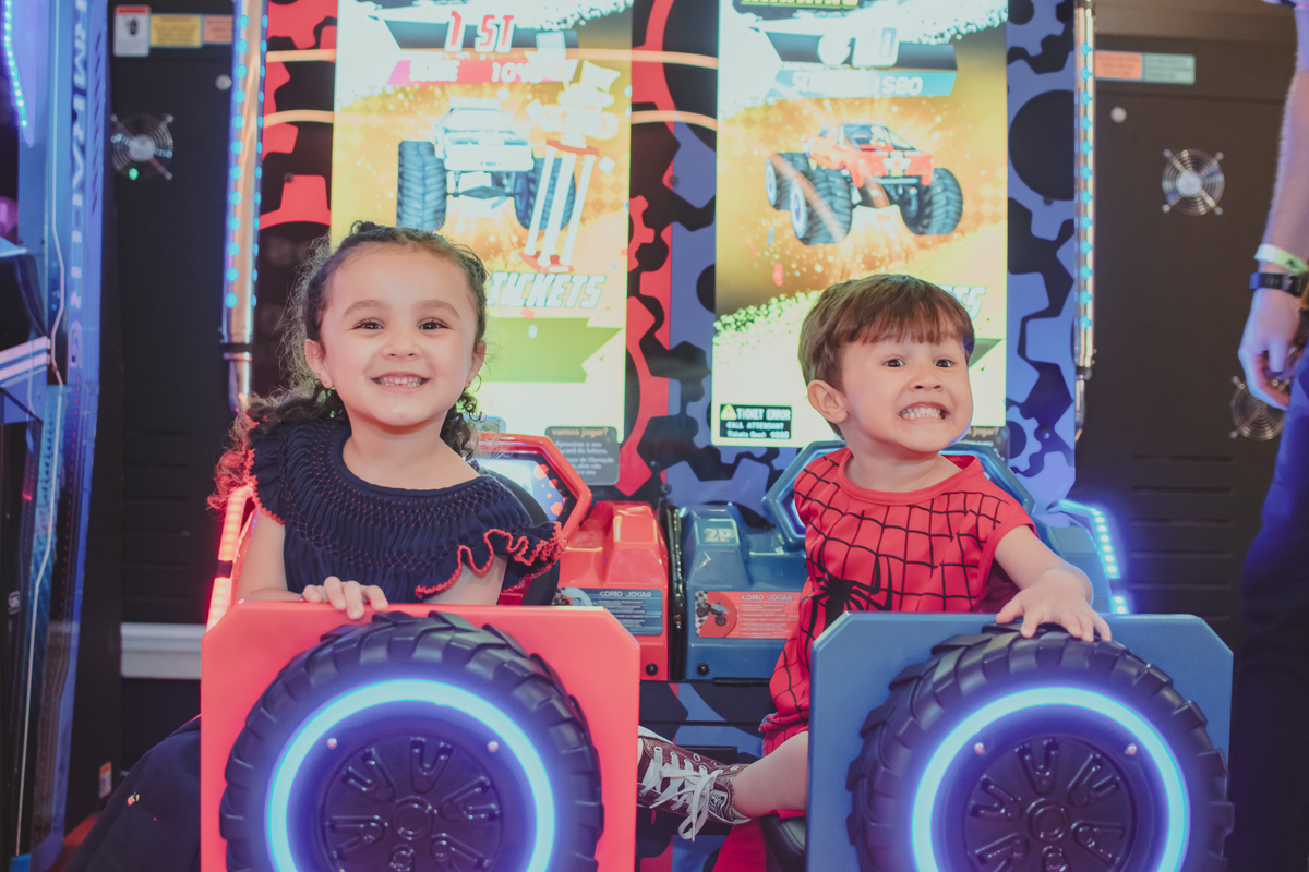 Duas crianças olhando para a camera sorrindo enquanto brincam no playcenter family, durante uma festa de aniversário.