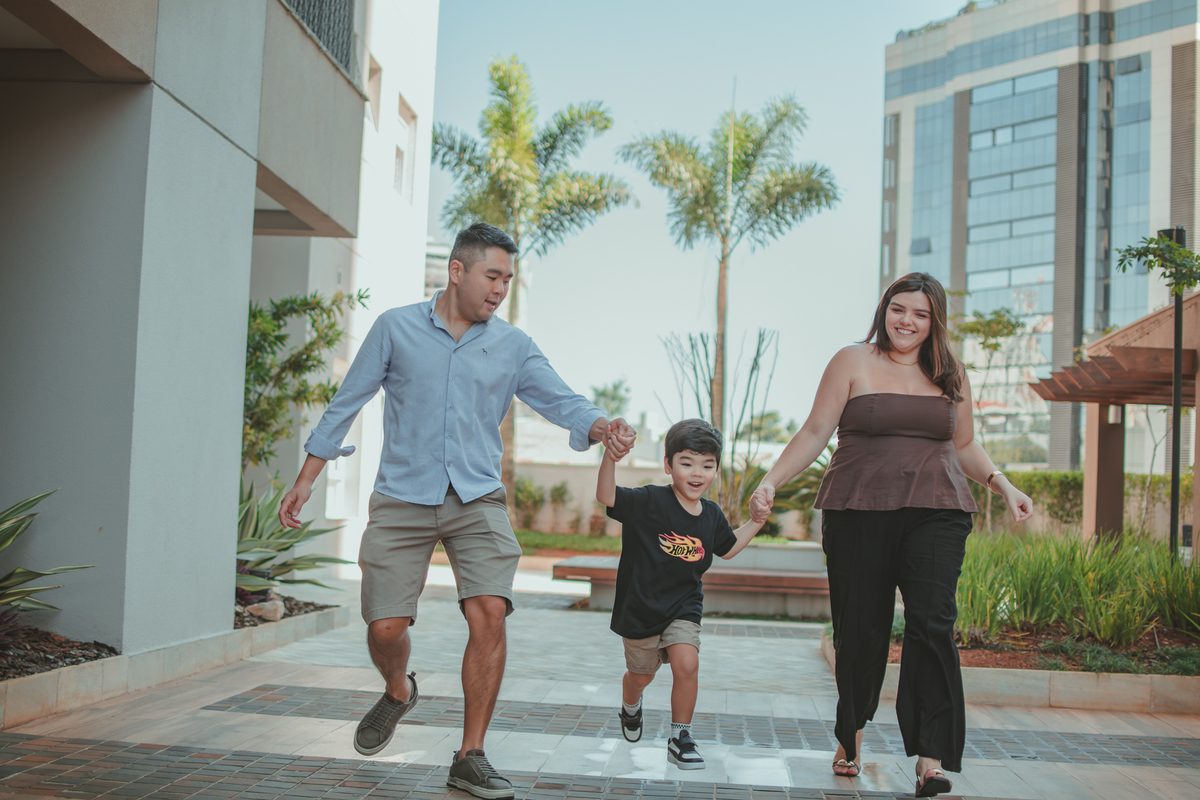uma família brincando de correr com o filho, durante o aniversário de 4 anos.