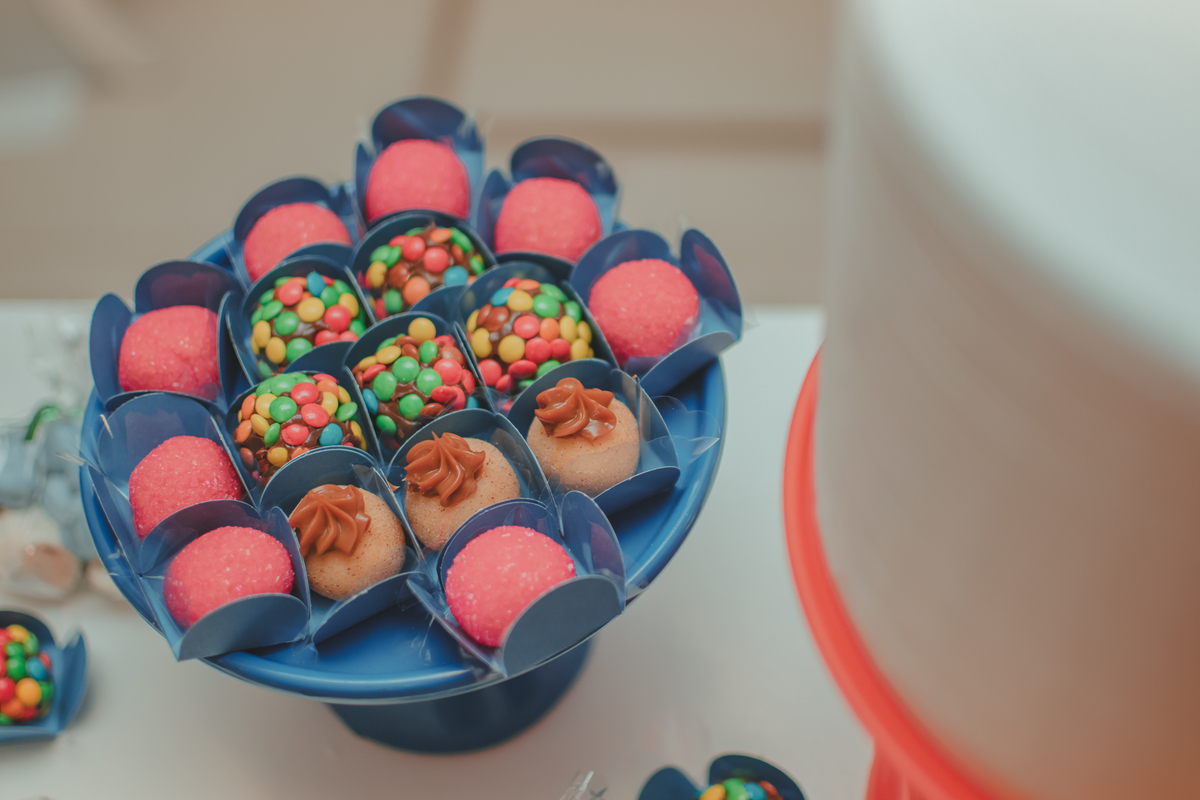 Docinhos de aniversário infantil, brigadeiros com confets, docinho de churros e morango.