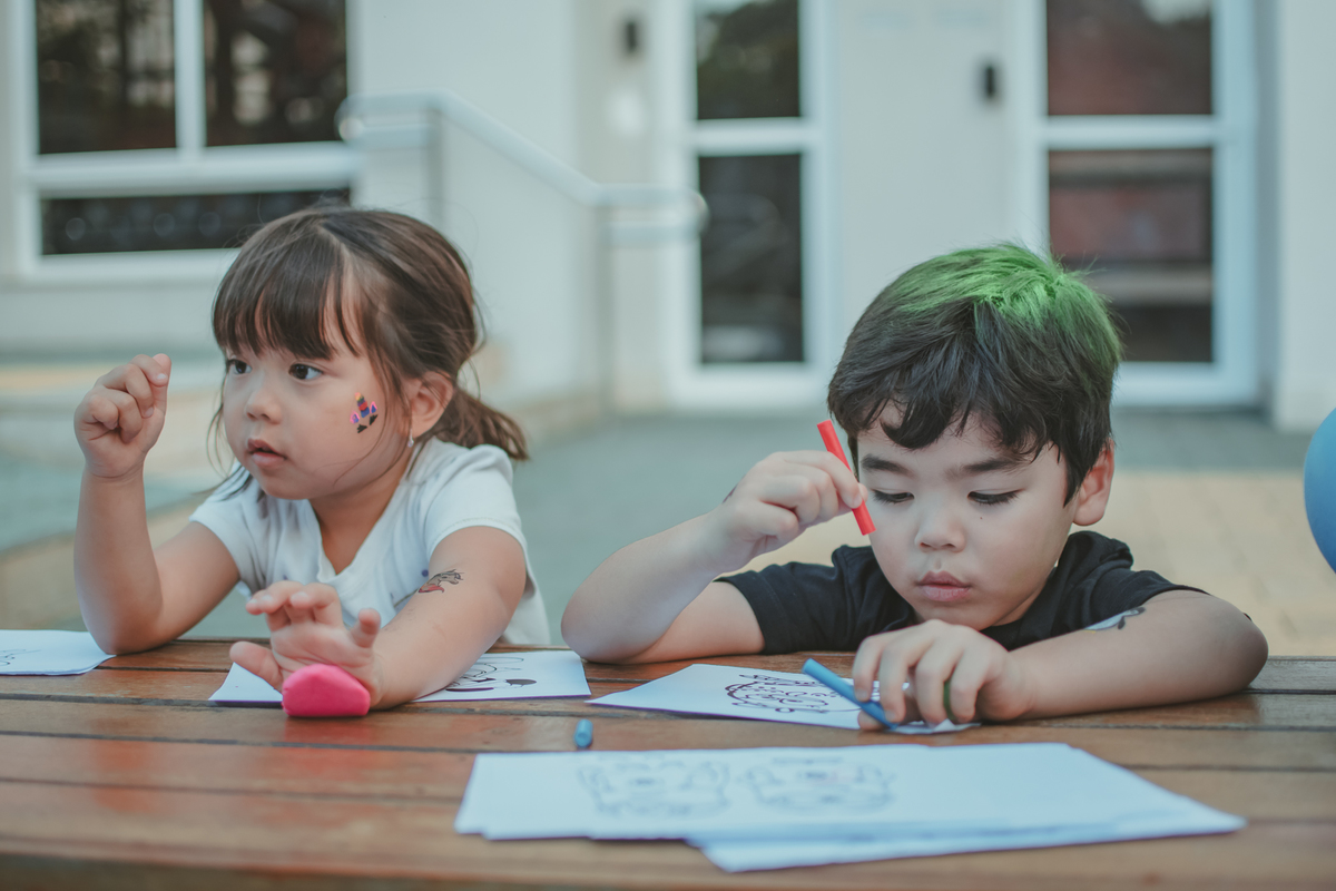 Varias crianças brincando de pintar durante uma festa de aniversário infantil.