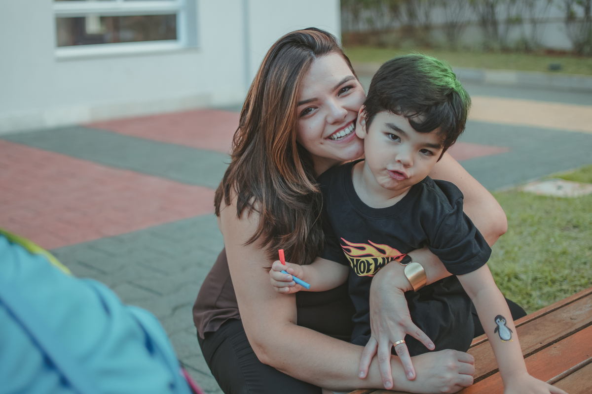 Uma mulher abraçada com seu filho durante a festa de aniversário de 4 anos.