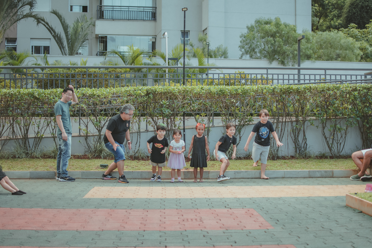 Varias crianças brincando de correr durante um aniversário infantil.