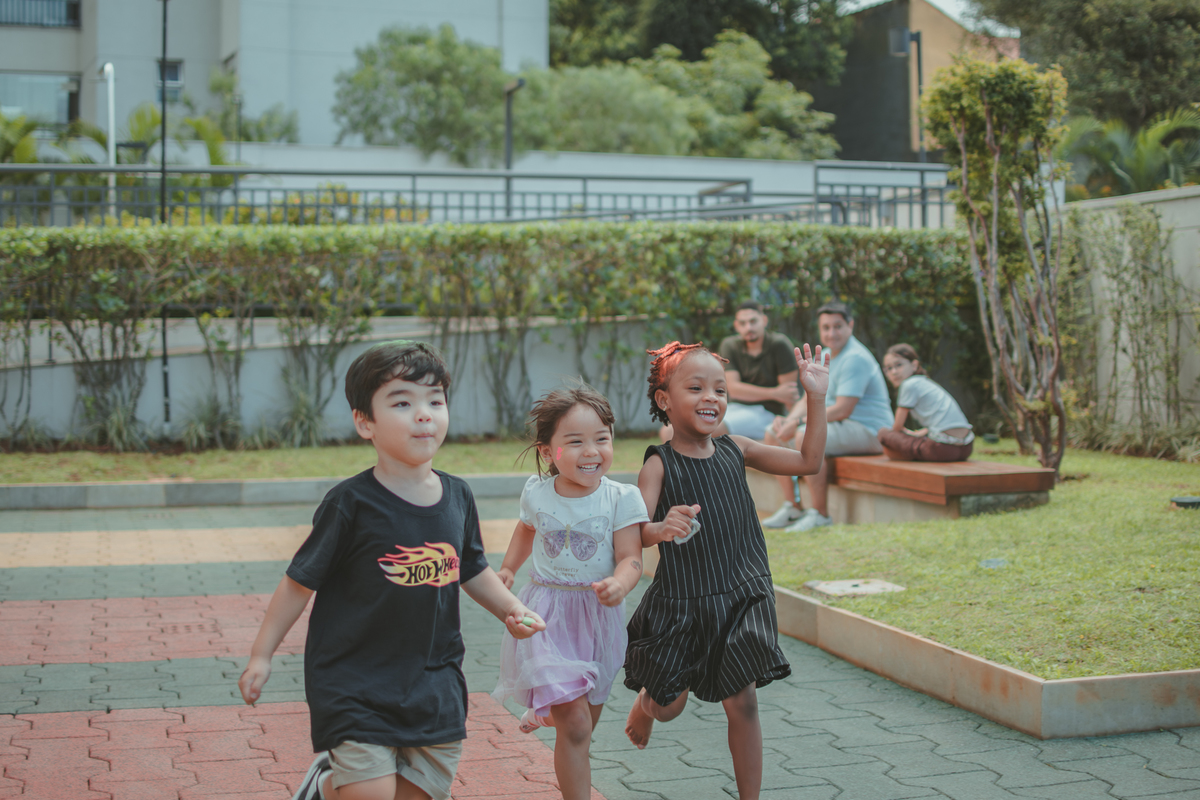 Varias crianças brincando de correr durante um aniversário infantil.