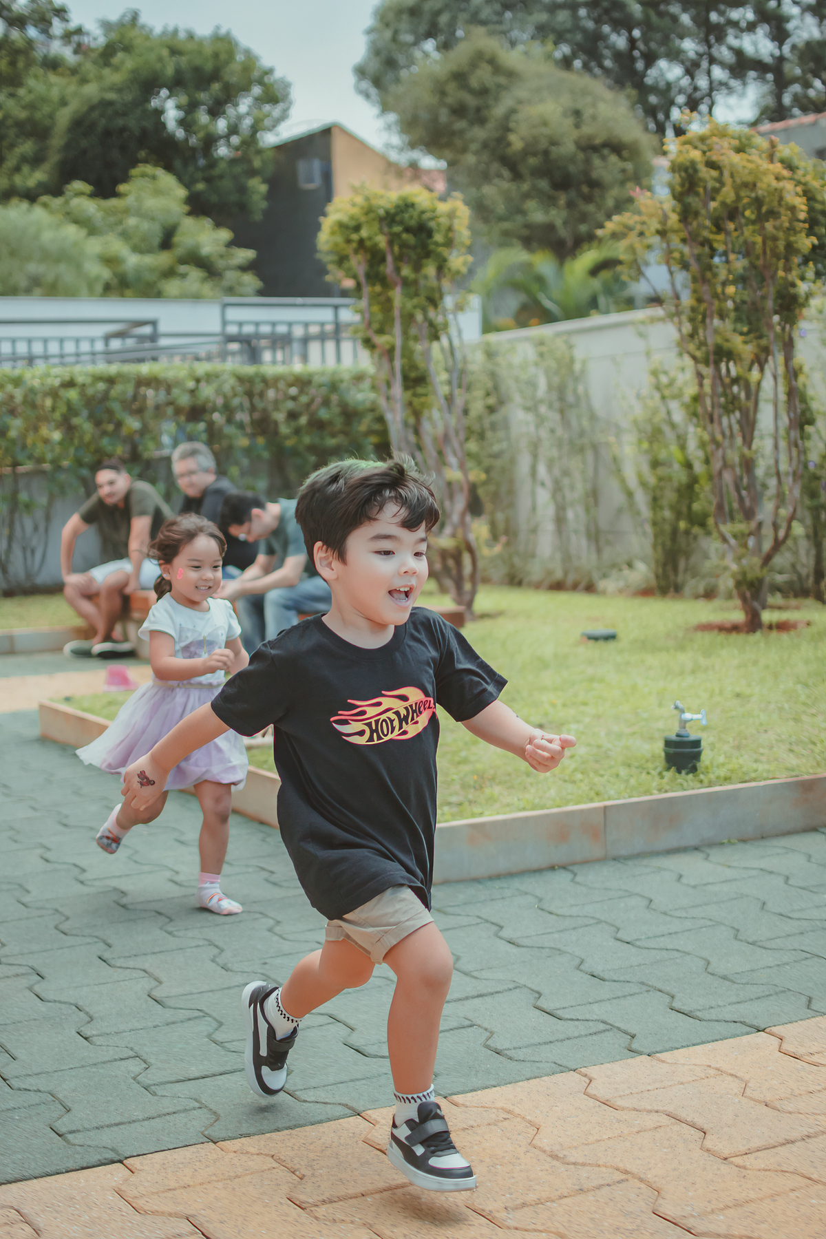 Varias crianças brincando de correr durante um aniversário infantil.