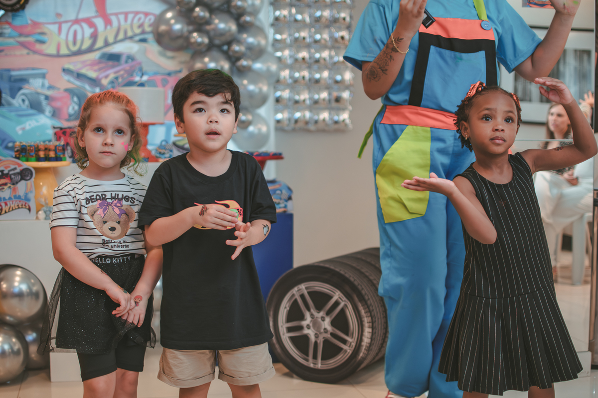 Varias crianças brincando de dançar durante um aniversário infantil.