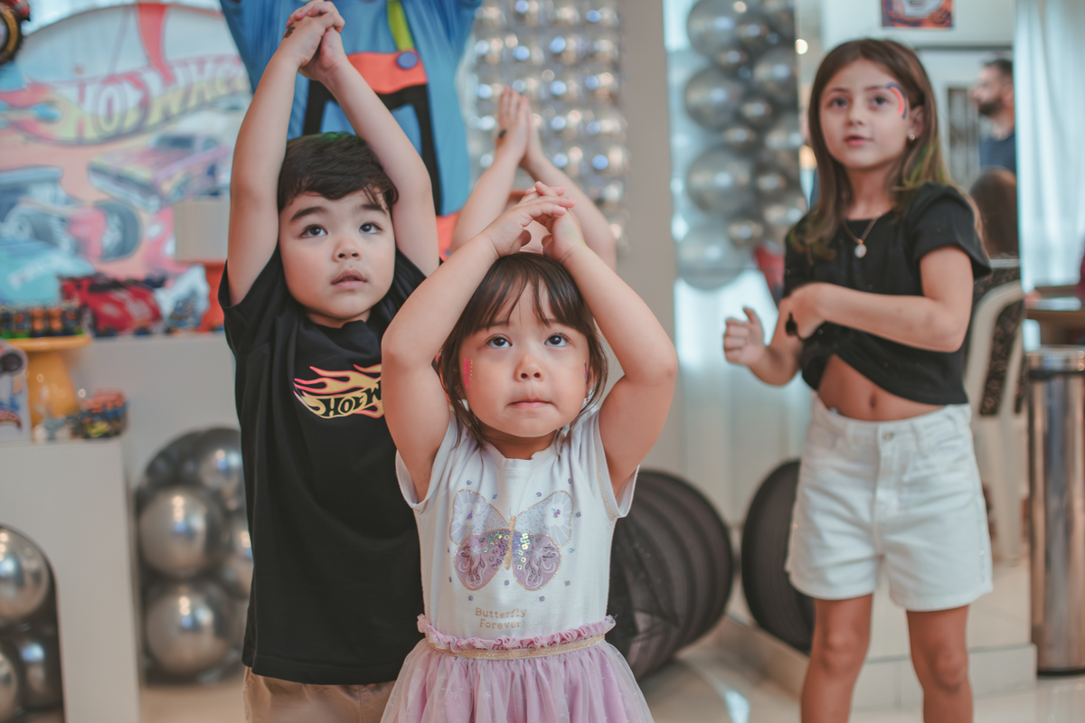 Varias crianças brincando de dançar durante um aniversário infantil.